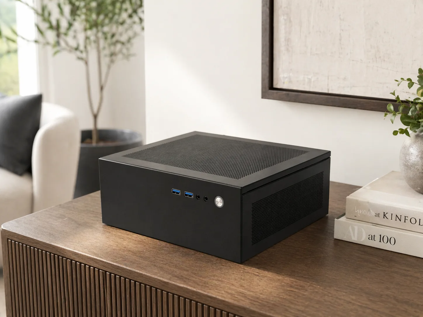 Companion Core 128 in black on a wooden console table next to a plant and a stack of books